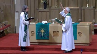 The Rev. Nadia Bolz-Weber, left, is installed as pastor of public witness Aug. 20, 2021, by Bishop Jim Gonia, right, of the Rocky Mountain Synod of the Evangelical Lutheran Church in America, in a service at Montview Boulevard Presbyterian Church in Denver. (Video screen grab)